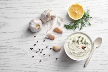 Ahşap masa üzerinde kase sarımsaklı lezzetli sos