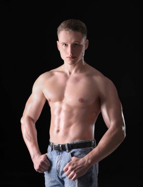 Koyu arka plan üzerinde kas genç vücut geliştirmeci