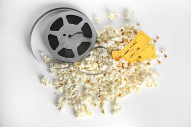 Lezzetli patlamış mısır, film reel ve biletleri beyaz arka planda, üstten görünüm