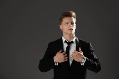 Gri arka plan üzerinde resmi kıyafetli yakışıklı adam
