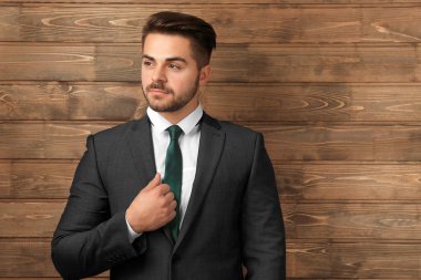 Ahşap arka plan üzerinde resmi kıyafetli yakışıklı adam