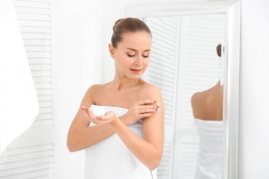 Genç kadın vücudunda banyo krem uygulamak