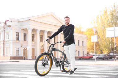 Yakışıklı genç hipster adam bisiklet üzerinde yaya geçidi ile