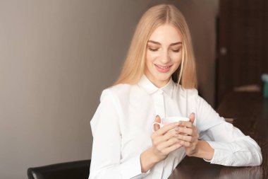 Gülümseyen kadın kapalı kahve ile