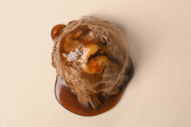 Çikolatalı dondurma topu renk arka plan üzerinde karamel sos ile