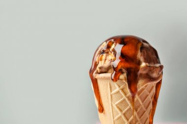 Gözleme koni dondurma ve gri arka plan üzerine karamel sos ile