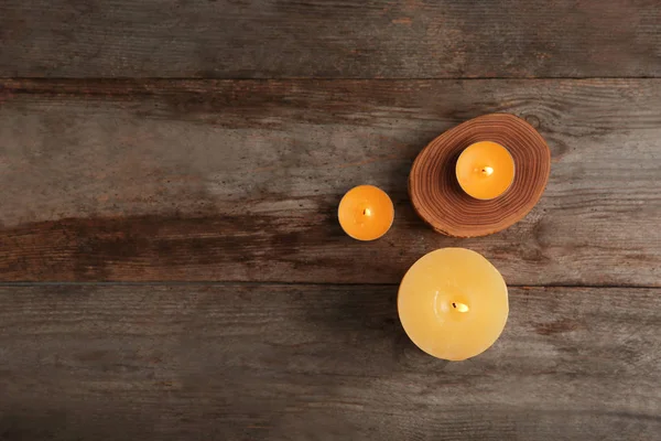 Burning candles on wooden background, top view — Stock Photo, Image