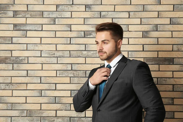 Hombre guapo en traje formal contra la pared de ladrillo —  Fotos de Stock
