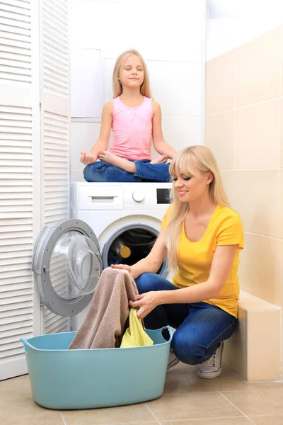 Figlia e madre che fanno il bucato a casa — Foto Stock