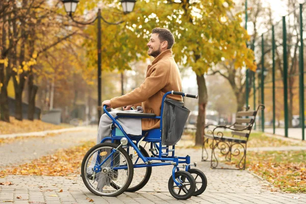 Jongeman in een rolstoel buiten — Stockfoto