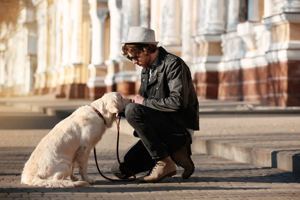 Guapo joven hipster con perro al aire libre — Foto de Stock