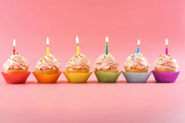 Leckere Cupcakes Mit Kerzen Auf Farbigem Hintergrund — Stockfoto
