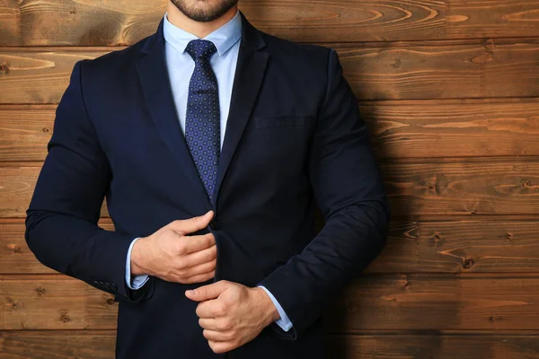 Όμορφος άνδρας στο επίσημο κοστούμι σε ξύλινα φόντο, κοντινό πλάνο — Φωτογραφία Αρχείου