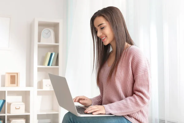 Jovem com laptop moderno em casa — Fotografia de Stock