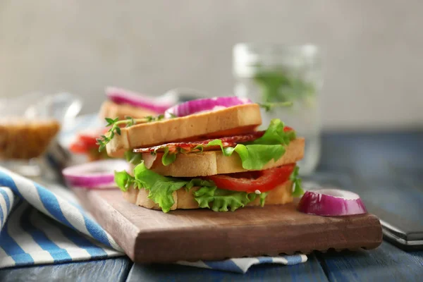 Delicioso sanduíche na placa de madeira, close-up — Fotografia de Stock