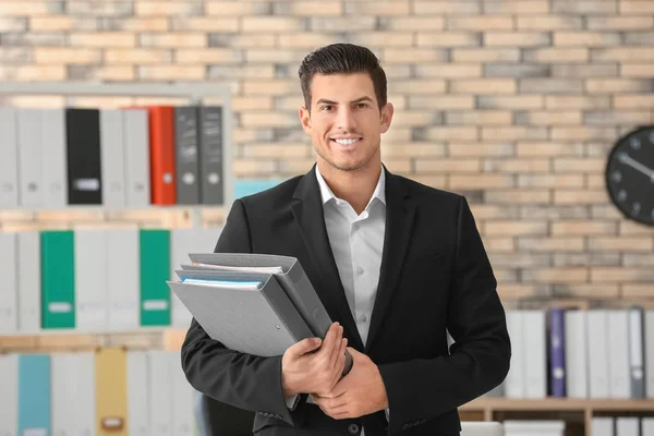 Ung man med dokument i office — Stockfoto