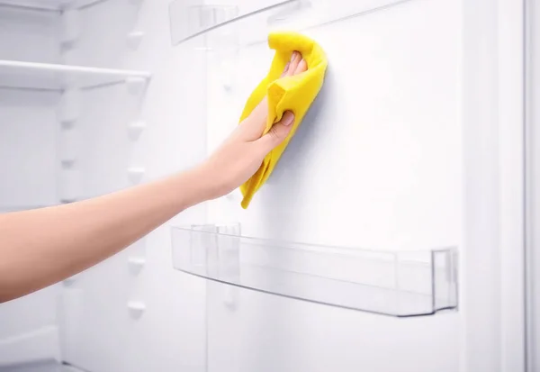 Woman cleaning refrigerator with rag, closeup — Stock Photo, Image