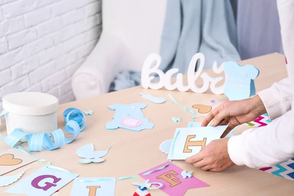 Woman preparing decorations for baby shower party on table — Stockfoto