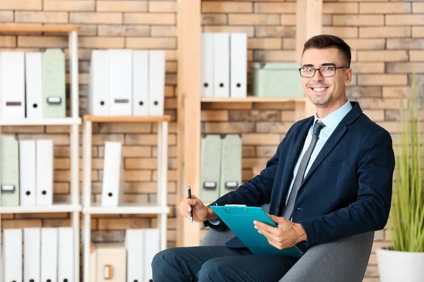 Handsome smiling male psychologist in office