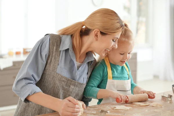 Mãe e filha com massa de farinha à mesa em casa — Fotografia de Stock