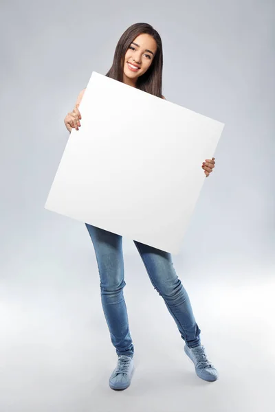 Νεαρή Γυναίκα Κενό Διαφημιστικό Πίνακα Επάνω Ελαφρύς Υπόβαθρο — Φωτογραφία Αρχείου