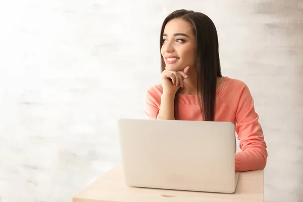 Jeune femme travaillant avec un ordinateur portable à la table — Photo