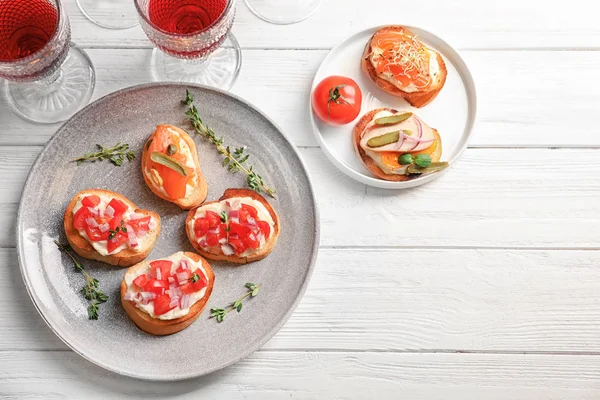 Placa con sabrosos bruschettas frescos en la mesa — Foto de Stock