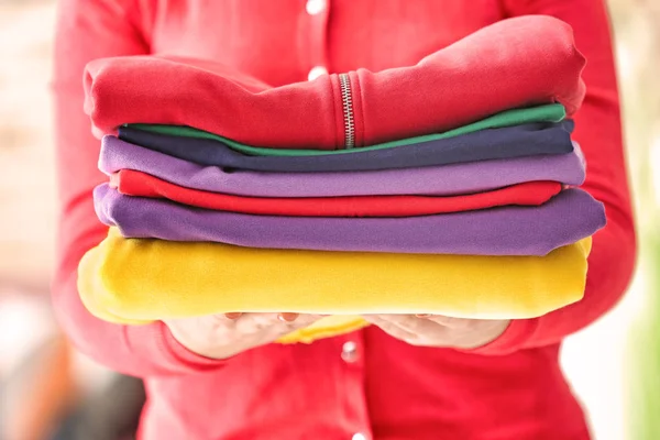 Vrouw Met Kleurrijke Kleding Stapel Onscherpe Achtergrond — Stockfoto