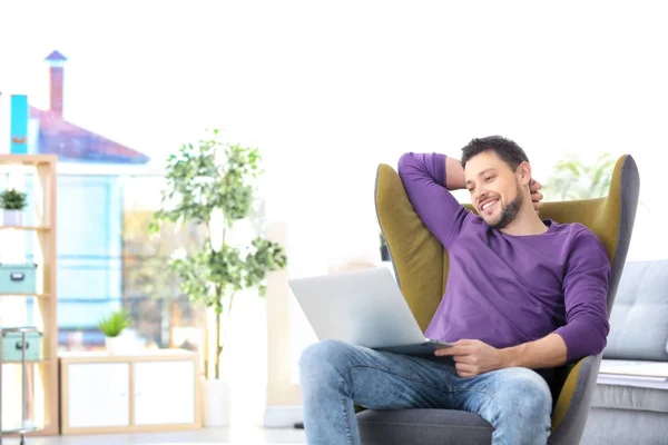 Joven Guapo Con Portátil Sentado Cómodo Sillón Casa —  Fotos de Stock