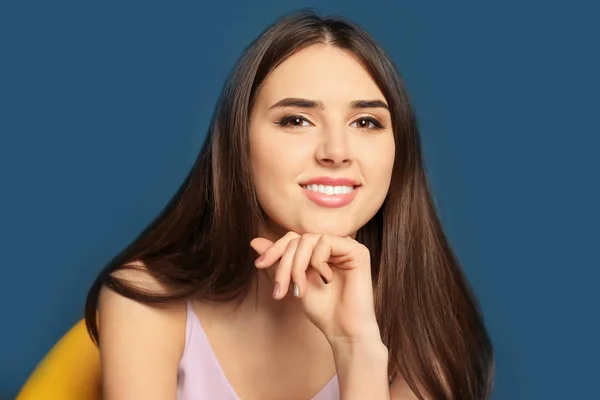 Attraente giovane donna sorridente su sfondo di colore — Foto Stock