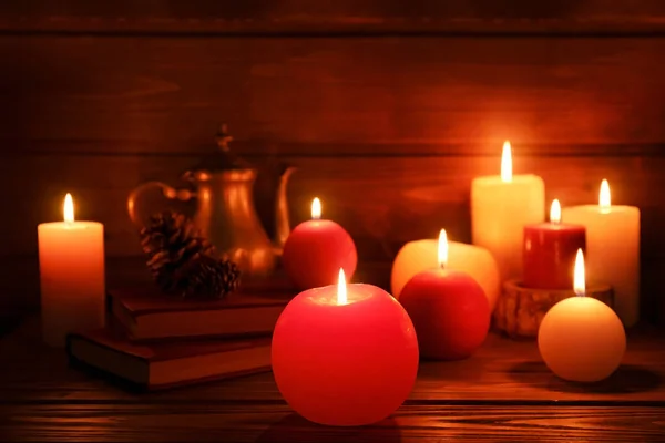 Brandende kaarsen op de tafel in duisternis, close-up — Stockfoto