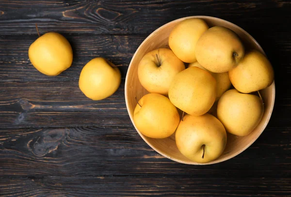 Holzschale mit reifen gelben Äpfeln auf dem Tisch — Stockfoto
