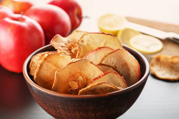 Чаша с вкусными яблочными чипсами на столе — стоковое фото
