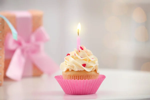 Birthday cupcake gyertya homályos háttérrel, Vértes asztalon — Stock Fotó