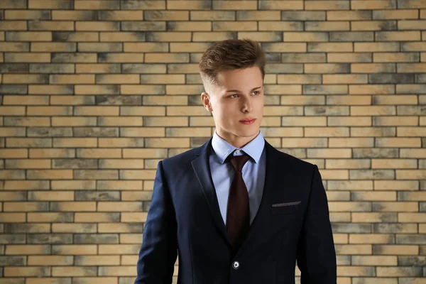 Handsome man in formal suit against brick wall — Stock Photo, Image