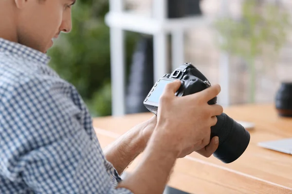 Joven fotógrafo profesional con cámara en la oficina — Foto de Stock