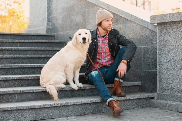 Красивый молодой хипстер с собакой на улице — стоковое фото