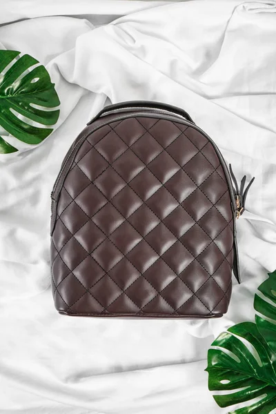 Stylish backpack with leaves on fabric background — Stock Photo, Image