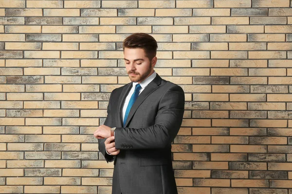 Hombre guapo en traje formal contra la pared de ladrillo —  Fotos de Stock