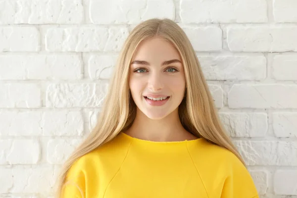 Uśmiechnięta Kobieta Żółtą Bluzę Tle Ściany Cegła — Zdjęcie stockowe