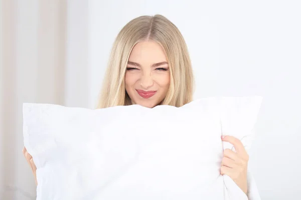 Mladá krásná usměvavá žena s polštářem doma — Stock fotografie