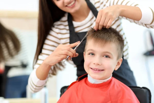 Kvinnlig Frisör arbetar med liten pojke i salongen, närbild — Stockfoto