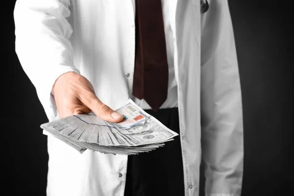 Γιατρός Κρατάει Χρήματα Σκούρο Φόντο Έννοια Της Διαφθοράς — Φωτογραφία Αρχείου