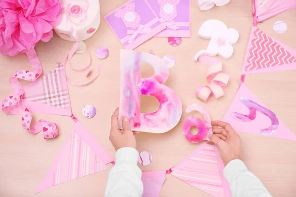 Kvinna som förbereder dekorationer för baby shower parti på bord — Stockfoto
