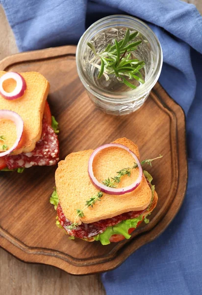 桌上有美味的三明治的木板 — 图库照片