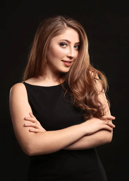 Mujer joven con color de pelo caramelo sobre fondo negro — Foto de Stock