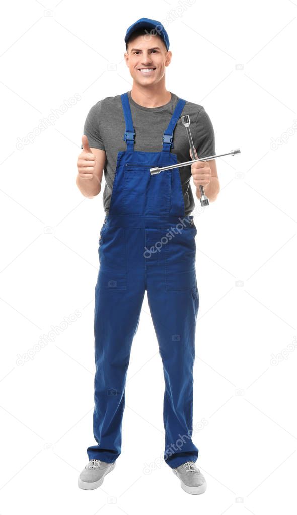 Handsome auto mechanic with wheel wrench on white background