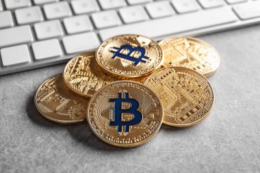 Gri arka plan üzerinde bilgisayar klavye ile altın bitcoins