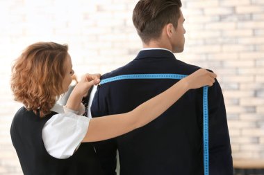 Atelier içinde müşterinin ölçümleri alarak terzi