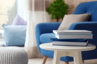 Masa ve koltuk oturma odasında kitap yığını